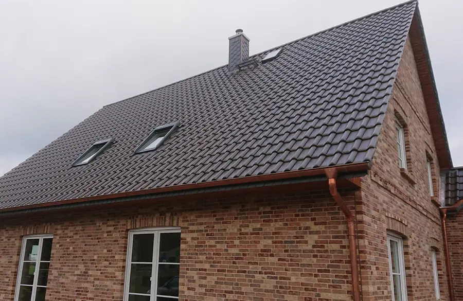 Neubau mit Satteldach, Kupferdachrinnen und Schieferverkleidung am Schornstein
