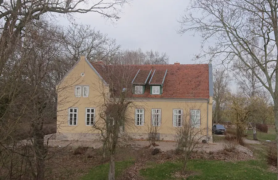 Denkmalschutzsanierung unter Verwendung historischer Dachsteine an einem alten Pfarrhaus.