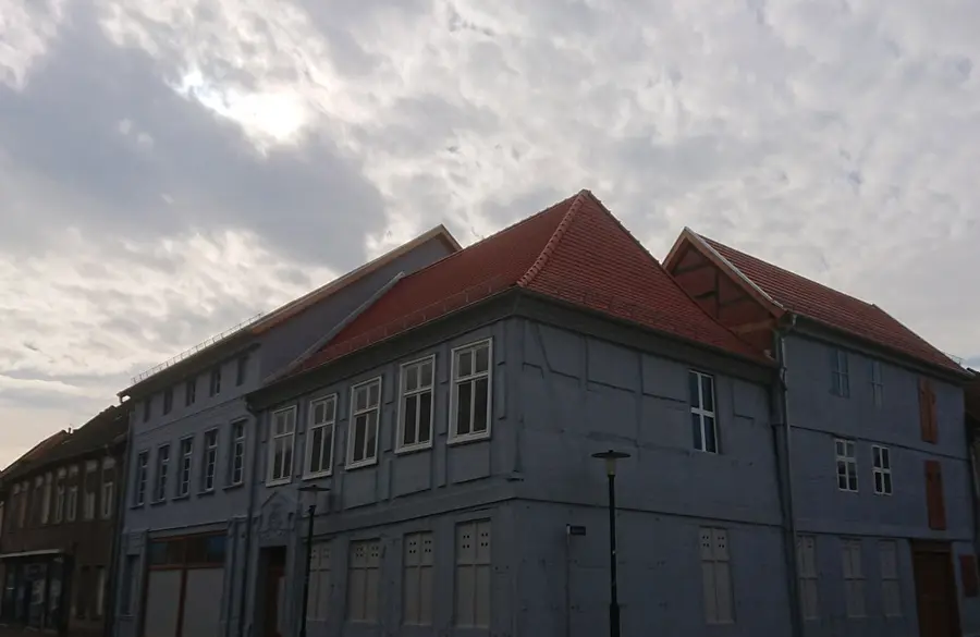 Altbausanierung Mehrfamilienhaus mit Kombination aus Satteldach und Walmdach, Schneeschutzgitter.