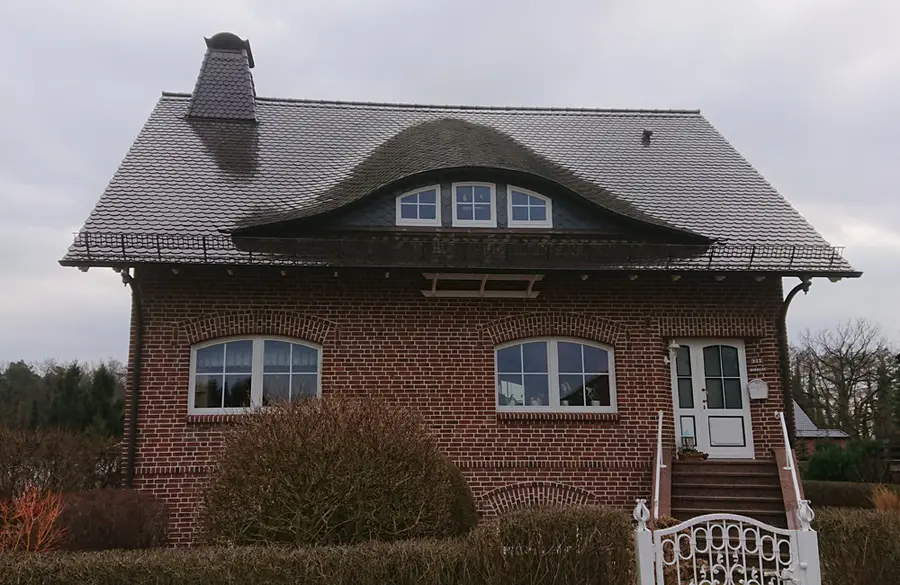 Wohnhaus mit Satteldach, Fledermausgaube in Biberschwanzdeckung und Schieferschornstein